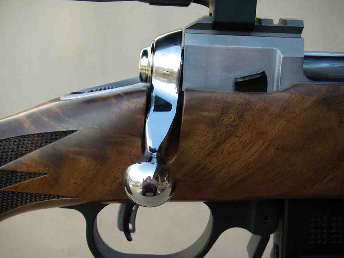 The rifle features a large, brightly polished bolt handle.